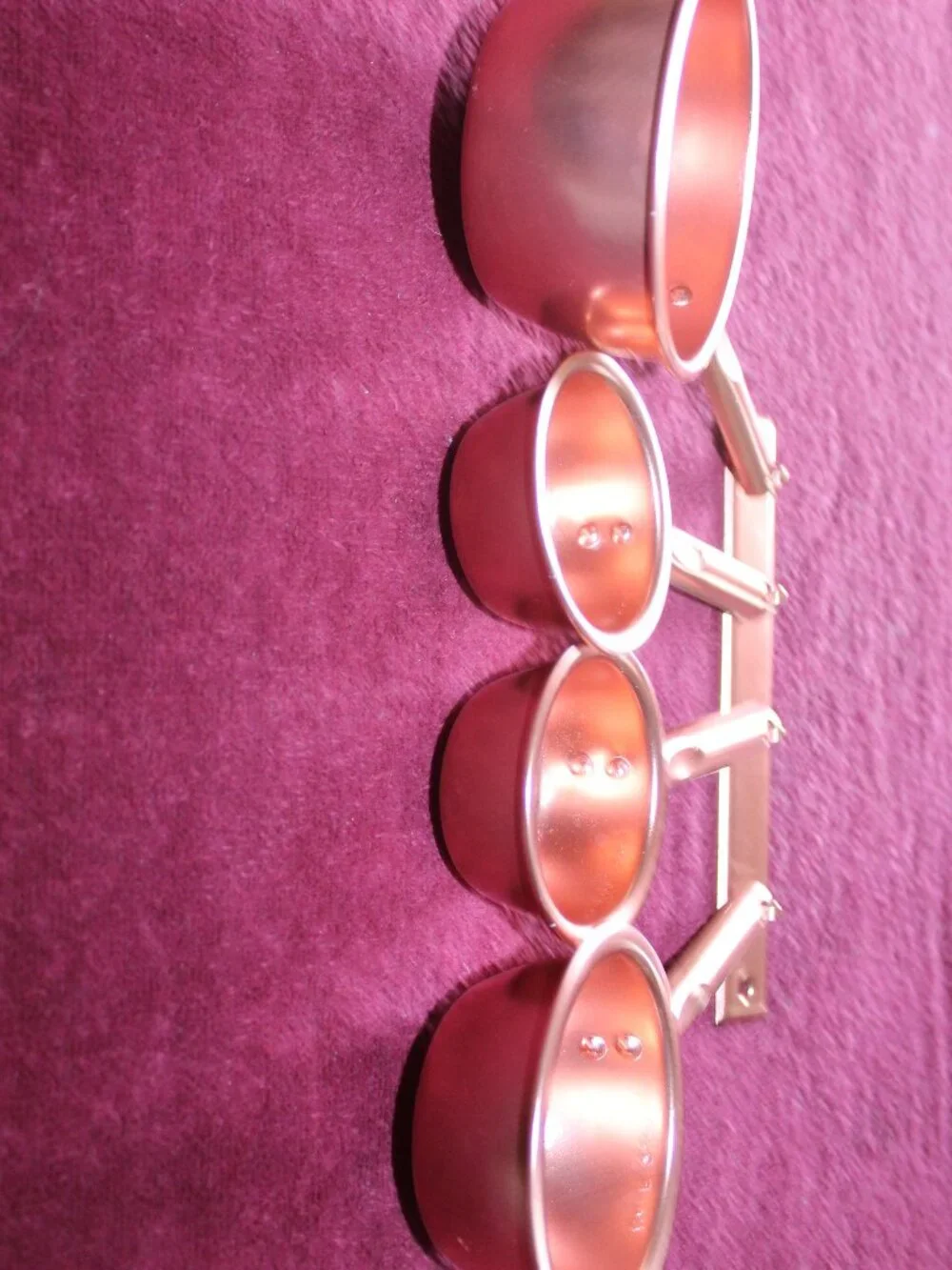 4-piece copper colored metal  measuring cups, complete with a matching hanger